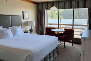 a hotel room with a large bed and a balcony at River House Inn, a Baymont by Wyndham in Florence