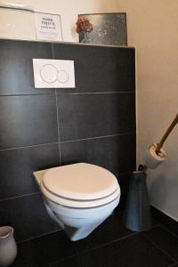 a bathroom with a white toilet and two rings on the wall at Appartement Jolimont 21 de 120m2 in Le Locle +22 photos