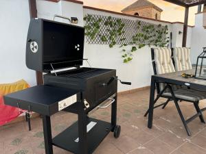 a bbq grill on a cart with a table at Apartamento Real 17, Cádiar in Cádiar