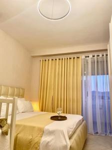 a bedroom with a bed with a table in front of a window at AT Home in Shkodër +10 photos