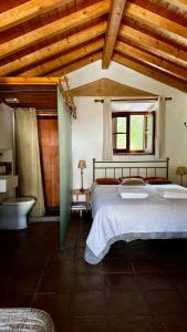 a bedroom with a large bed and a bathroom at Casas da Cerca in Troviscais