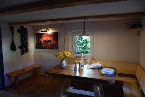 a dining room with a wooden table and a window at Alte Stellmacherei in Nieder Neundorf