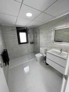 ein weißes Badezimmer mit Toilette und Waschbecken in der Unterkunft Casa Blanca y Negra in San Pedro del Pinatar