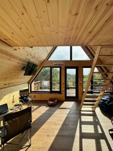 an attic room with wooden ceilings and windows at Green Hill Glamping in Almaty