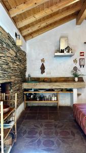 a kitchen with a stone wall and a counter with pots and pans at Casas da Cerca in Troviscais