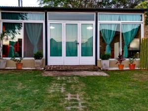 a house with a white door and windows at El Descanso in San Antonio de Areco