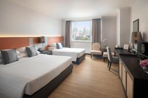 a hotel room with two beds and a television at The Berkeley Hotel Pratunam in Bangkok