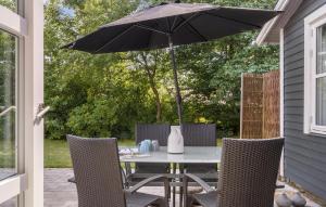 a table and chairs with an umbrella on a patio at 3 Bedroom Lovely Home In Skjern in Skjern +10 photos