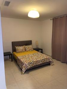a bedroom with a bed and two tables and a light at Charmant appartement pour famille uniquement en résidence à Oran Gambetta in Oran +12 photos