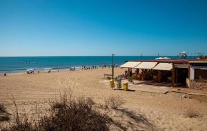 - une plage avec un groupe de personnes et l'océan dans l'établissement Cozy Apartment In Isla Cristina, à Isla Cristina