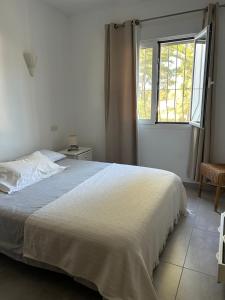 a bedroom with a white bed and a window at Tranquil setting in Moraira +25 photos