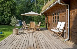 a wooden deck with a table and an umbrella at 3 Bedroom Beautiful Home In Melby in Melby +13 photos