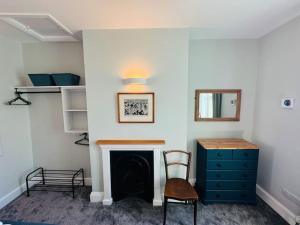 a living room with a fireplace and a blue dresser at Totterdown House with Views & Garden in Bristol +42 photos