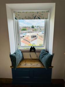 a window with two pillows on a bench in front of it at Totterdown House with Views & Garden in Bristol