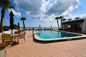 サラソタにあるPrivate Beach Condo On Lido Keyの海を望むスイミングプール(テーブル、椅子付)