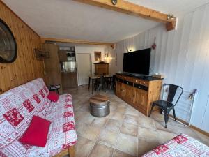a living room with a couch and a flat screen tv at Très beau studio rénové Puy Saint Vincent 1600 in Puy-Saint-Vincent