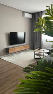 a living room with a flat screen tv on a wall at Апартаменты в ЖК Green Plaza с джакузи in Aktau
