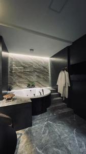 a bathroom with a tub and a staircase with towels at Апартаменты в ЖК Green Plaza с джакузи in Aktau