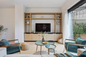 ein Wohnzimmer mit Sofa und Fernseher in der Unterkunft Triton luxe gelijkvloers appartement met tuin en gratis garage in Knokke-Heist