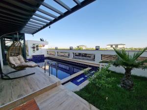 eine Terrasse mit einem Stuhl neben einem Pool in der Unterkunft Perfect Family Villa Golden Life in Dosemealti