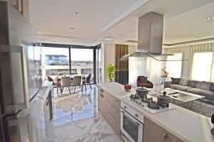 eine Küche mit einem Herd und ein Wohnzimmer in der Unterkunft Perfect Family Villa Golden Life in Dosemealti