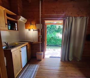 a kitchen with a door open to a yard at Camping La Vall d'Hostoles in Sant Feliu de Pallerols