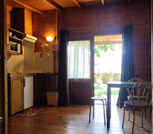 a kitchen and dining room with a table and chairs at Camping La Vall d'Hostoles in Sant Feliu de Pallerols +9 photos