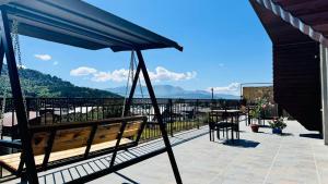 a balcony with a bench and a view of the mountains at The Grand Hotel Bakuriani in Bakuriani