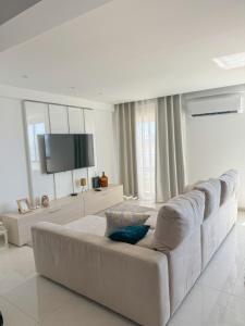 a white living room with a large white couch at Riamar House - Faro City Center in Faro