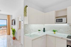 a white kitchen with a sink and a microwave at Atlantic Sky Panorama in Costa Del Silencio