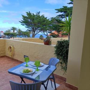 a blue table with a plate of food on a balcony at Golden Beach House in Porto Santo