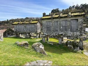 an old stone building with windows in a field at Destro village in Lindoso