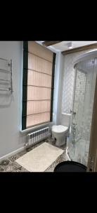 a bathroom with a toilet and a window at Уютный домик в Боровом in Borovoye +21 photos