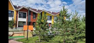 a row of houses with trees in front of them at Уютный домик в Боровом in Borovoye