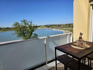 a table on a balcony with a view of a river at Lakeside Provence - Appartement classé 4 étoiles, Vue sur le lac, Parking sous-sol, double clim in Monteux