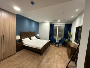 une chambre avec un lit et un mur bleu dans l'établissement Penta Square Apartments, à Lahore 4 autres photos