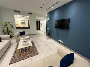 a living room with a couch and a tv on a blue wall at Penta Square Apartments in Lahore +4 photos