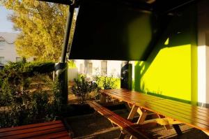 eine Holzbank neben einer grünen Wand in der Unterkunft Lemon Hotel Plan de Campagne Marseille in Septèmes-les-Vallons