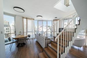a living room with a dining room table and stairs at David Frishman Residence - Sea view penthouse in Tel Aviv