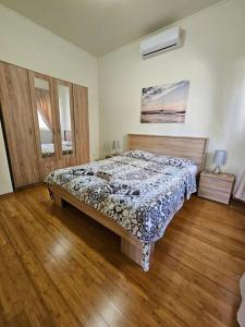 ein Schlafzimmer mit einem Bett und einem Holzboden in der Unterkunft Deniz Apartment Kotor bay view apartment with terrace and pool in Prčanj