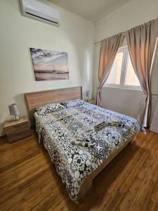 ein Schlafzimmer mit einem Bett mit einer Bettdecke darauf in der Unterkunft Deniz Apartment Kotor bay view apartment with terrace and pool in Prčanj + 10 Fotos