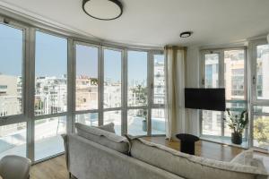 テルアビブにあるDavid Frishman Residence - Sea view penthouseのソファと大きな窓のあるリビングルーム