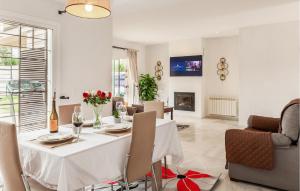 a dining room and living room with a table and chairs at Beautiful Home In Bollullos De La Mitaci in Bollullos de la Mitación