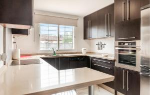 a kitchen with dark brown cabinets and a sink at Beautiful Home In Bollullos De La Mitaci in Bollullos de la Mitación