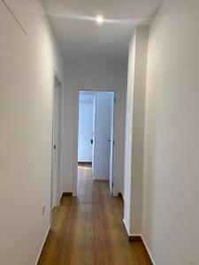 an empty hallway with white walls and wood floors at Apartamento Happy Street 3 in Socuéllamos
