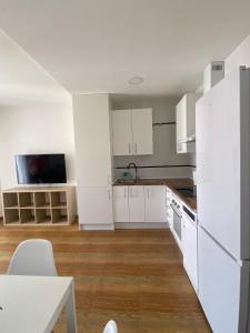 a white kitchen with white cabinets and a table at Apartamento Happy Street 3 in Socuéllamos