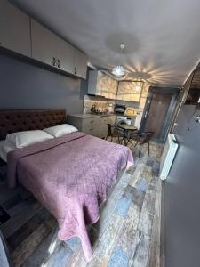 a bedroom with a large bed and a kitchen at Apartment- GURO in Batumi