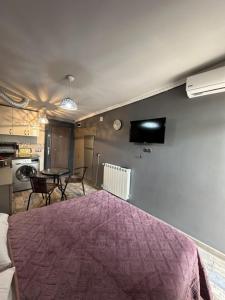 a bedroom with a bed with a purple blanket at Apartment- GURO in Batumi