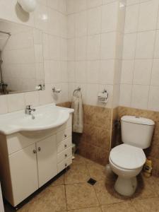 a bathroom with a white toilet and a sink at Марина Кейп in Aheloy