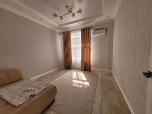 a living room with a couch and a window at квартира in Aktau